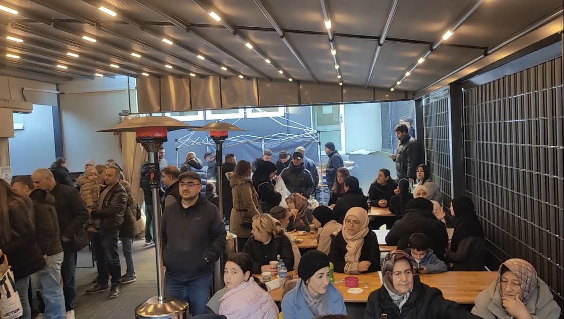 Gemeindeveranstaltung im Außenbereich mit Besuchern an Tischen